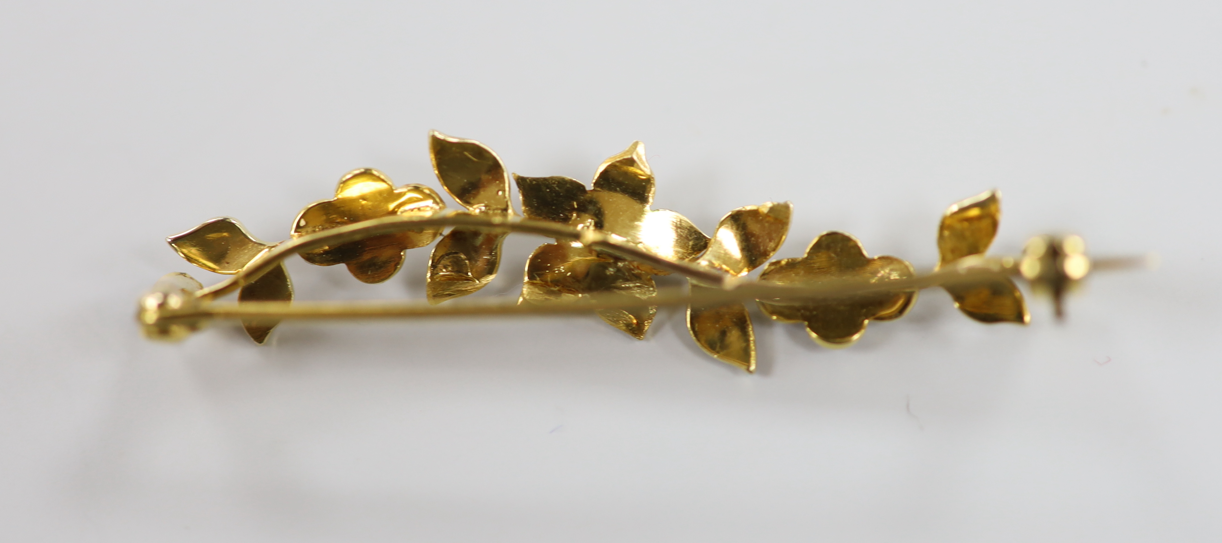 An Edwardian yellow metal and split pearl set foliate bar brooch, 50mm, gross weight 4.5 grams.